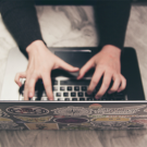 pair of hands writing an email on a laptop