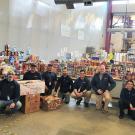 Members of the Campus Mail Services team pose with a large collection of food and non-perishable items. 