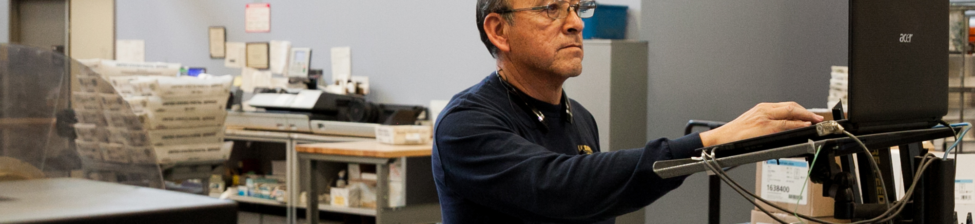 man working at a computer in a shipping facility
