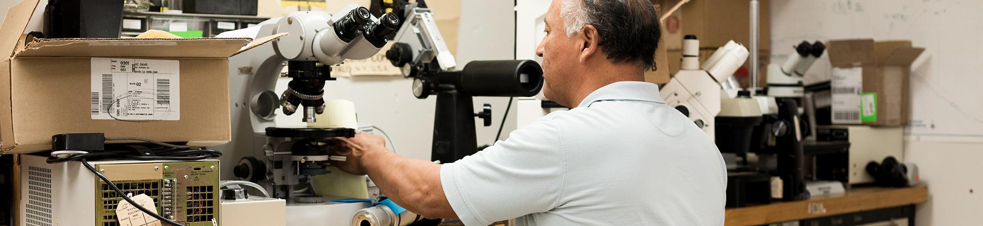 man working in a microscope repair workshop